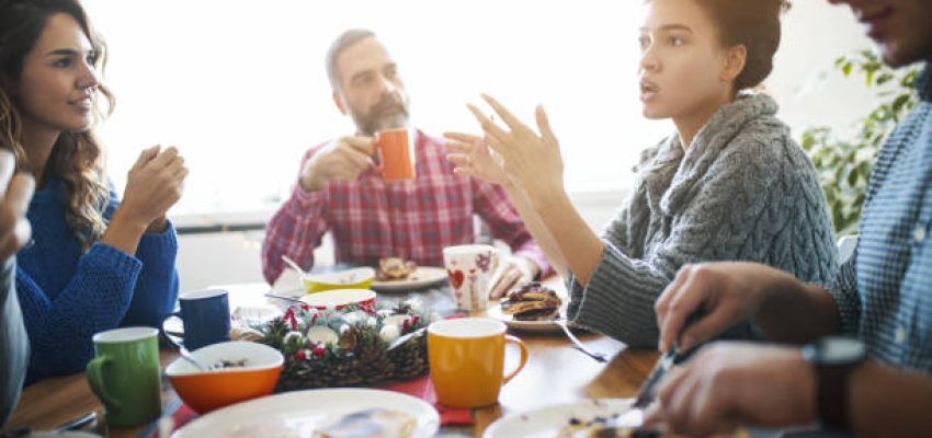 Closeup of multi generation family having lunch at home. They are talking about some serious issues, one of the young women is explaining something
